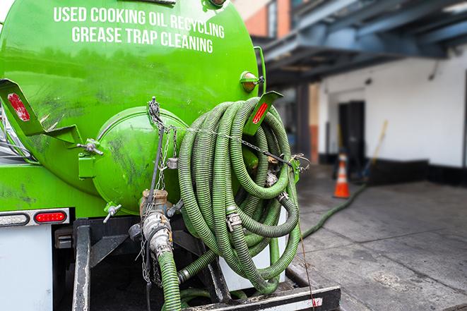 a technician pumping a grease trap in a commercial building in New Brighton, MN